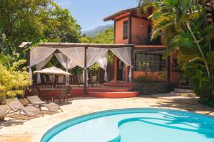 a swimming pool in front of a house at Pousada Villaggio Assis in Ilhabela