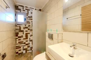 a bathroom with a sink and a toilet and a mirror at Studios Sotiria 1 in Astris