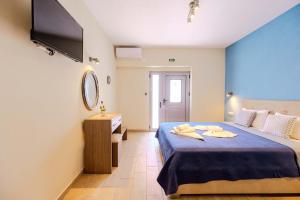 a bedroom with a blue bed and a television at Studios Sotiria 1 in Astris