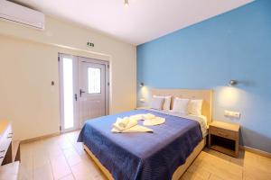 a bedroom with a bed with two towels on it at Studios Sotiria 1 in Astris