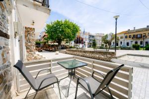 a balcony with two chairs and a table and a street at Studios Sotiria 1 in Astris