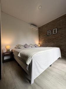 a bedroom with a large bed and a brick wall at Rio Olón ecolodge in Olón