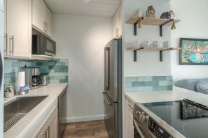 a kitchen with white cabinets and a black refrigerator at 401 Maalaea Banyans in Wailuku
