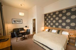 a hotel room with a bed and a table and chairs at The White House in Kinsale