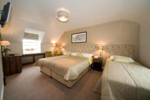 a hotel room with two beds and a window at The White House in Kinsale +32 photos