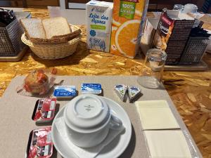 a table with a plate of bread and a cup of coffee at AZORES HOLIDAYS HOUSE -B&B - Suites - Self Check-in KEYBOARD in Ponta Delgada