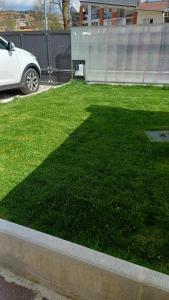 a grassy yard with a white car parked in a driveway at il Biscottino in Castel di Sangro