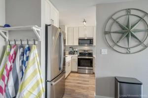 a kitchen with a refrigerator and a clock on the wall at 214 Kihei Holiday in Kihei