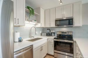 a white kitchen with a sink and a microwave at 214 Kihei Holiday in Kihei