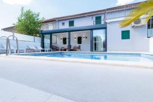 a swimming pool in front of a house at Holiday house Mala in Sinj