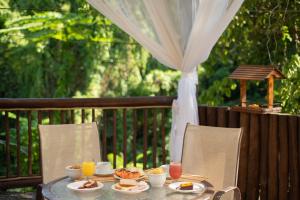 a table with plates of food and drinks on it at Pousada Villaggio Assis in Ilhabela