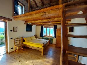 a bedroom with a yellow bed and a wooden floor at Agriturismo Zertin in Gravedona