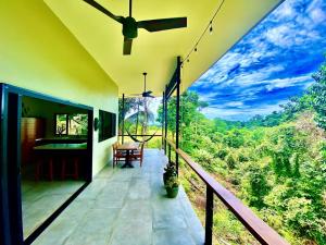 a balcony of a house with a view of the forest at Tierra Encantada in Dominicalito