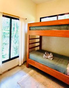 a bedroom with two bunk beds and a window at Tierra Encantada in Dominicalito