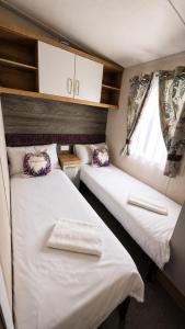 two beds in a small room with a window at 14B Medina Rise Ferry Offers Available in Porchfield
