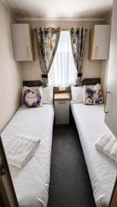 two beds in a small room with a window at 14B Medina Rise Ferry Offers Available in Porchfield +29 photos