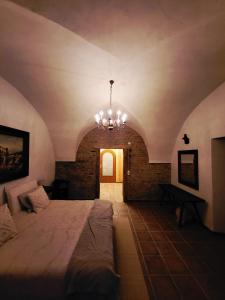 a bedroom with a large bed and a chandelier at Brick House in Fürstenfeld