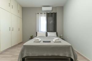 a bedroom with a bed with two towels on it at Gkr Luxury Apartments Metro Petralona in Athens