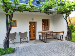 a picnic table and two chairs on a patio at Éva Apartmanház 2 in Csopak +4 photos