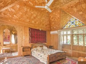 a bedroom with a bed and a ceiling fan at The Martin's Houseboat in Srinagar