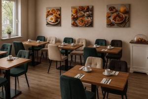 ein Speisesaal mit Tischen, Stühlen und Tellern mit Essen in der Unterkunft Hotel Schwarzenbek in Schwarzenbek