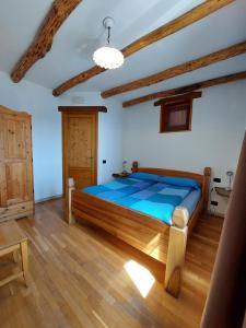 a bedroom with a large bed in a room with wooden floors at Agriturismo Zertin in Gravedona