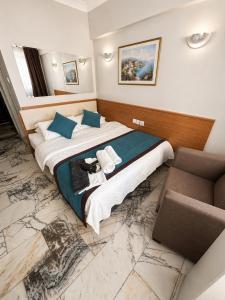 ein Hotelzimmer mit einem großen Bett und zwei Stühlen in der Unterkunft Brand Otel in Didim + 20 Fotos
