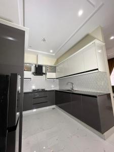 a kitchen with white and gray cabinets and appliances at premium category 2 bedrooms apartment in Lahore +16 photos