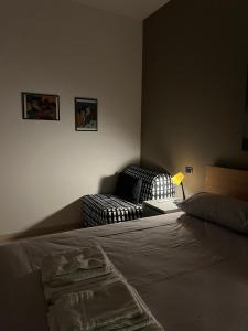 a bedroom with a bed with a lamp and a couch at LA Tulè 2 in Popoli