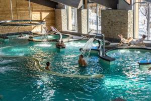 a group of people playing in a swimming pool at Le Cottage des Pléiades in Les Angles
