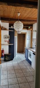 a kitchen with blue counters and a ceiling with a chandelier at Gîte La petite maison 2 ch bain nordique privé Skadi & sauna in Les Fontenelles