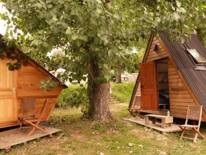 a cabin with two chairs next to a tree at Aparra Surfcamp Auberge Hendaye in Hendaye