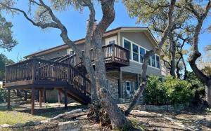 a house with a deck in the middle of trees at Canyon Lake House with Lake View in Canyon Lake