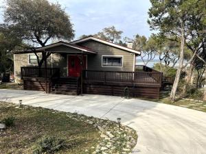 a small house with a red door and a driveway at Canyon Lake House with Lake View in Canyon Lake
