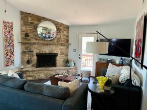 a living room with a blue couch and a stone fireplace at Canyon Lake House with Lake View in Canyon Lake