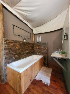 a bathroom with a large tub and a sink at Rustic Gate Lodge and Campsite in Maun +62 photos