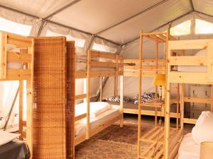 a room with three bunk beds in a tent at Aparra Surfcamp Auberge Hendaye in Hendaye