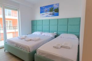 a bedroom with two beds with towels on them at Hotel Sea View Shëngjin in Lezhë