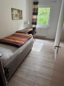 a room with a bed and a desk and a window at Fewo Am Poetenteich in Jänkendorf +9 photos
