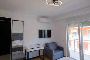 a room with a chair and a tv and a bed at Hotel Sea View Shëngjin in Lezhë