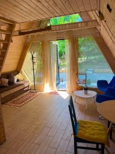 a living room with a large window in a house at Narnia Cottages in Bazalet'i +27 photos