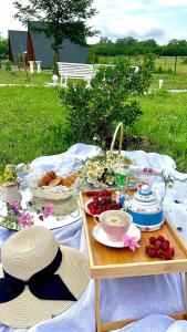 a picnic with a table with food and hats on it at Narnia Cottages in Bazalet'i
