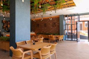 a restaurant with tables and chairs and a brick wall at Hotel Sea View Shëngjin in Lezhë