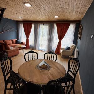 a living room with a wooden table and chairs at Narnia Cottages in Bazalet'i