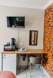 a room with a desk with a television on a wall at Adriaan Place in Bethlehem