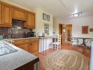 a kitchen with wooden cabinets and a table with chairs at The Lodge in Colchester
