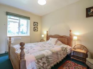 a bedroom with a wooden bed and a window at The Lodge in Colchester