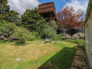 a garden with a bench and a water tower at The Lodge in Colchester