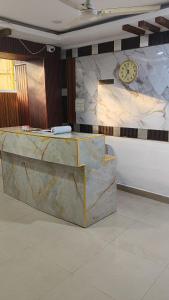 a marble counter with a clock on a wall at HOTEL BPR Residency in Hyderabad