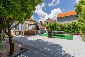 a patio with a table and a tree at Holiday house Mala in Sinj